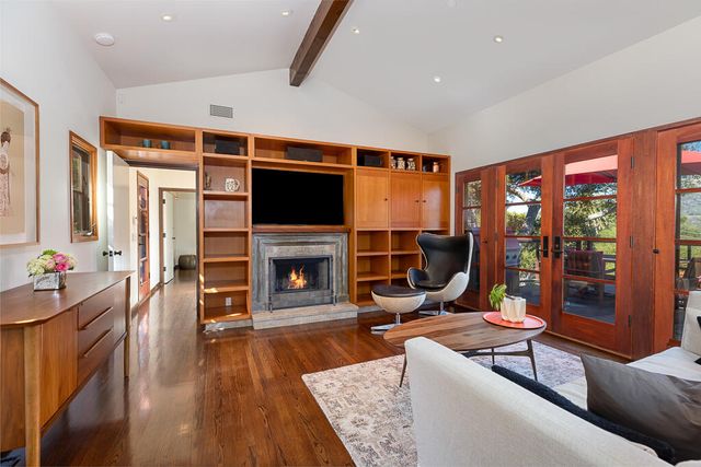 a living room with furniture a fireplace and a flat screen tv