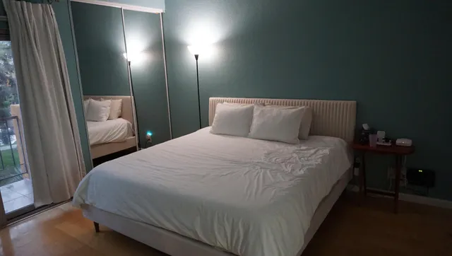 a bedroom with a bed and a large window