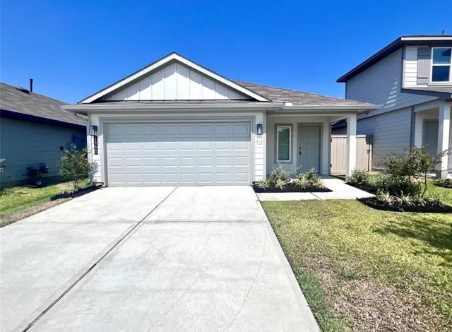 a front view of a house with a yard and potted plants