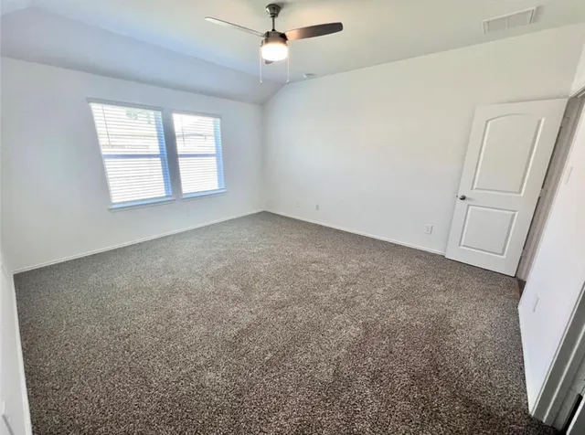 an empty room with windows and fan