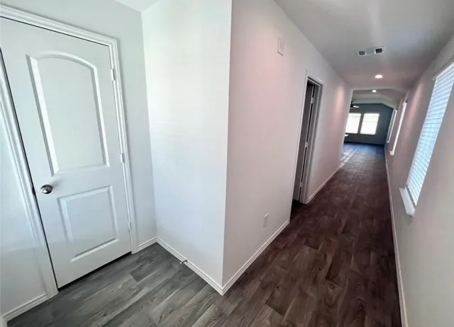 a view of a hallway with wooden floor