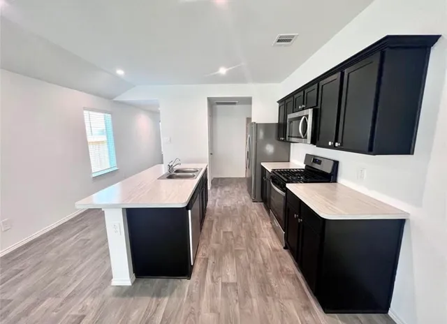 a kitchen with a sink a counter top space and appliances