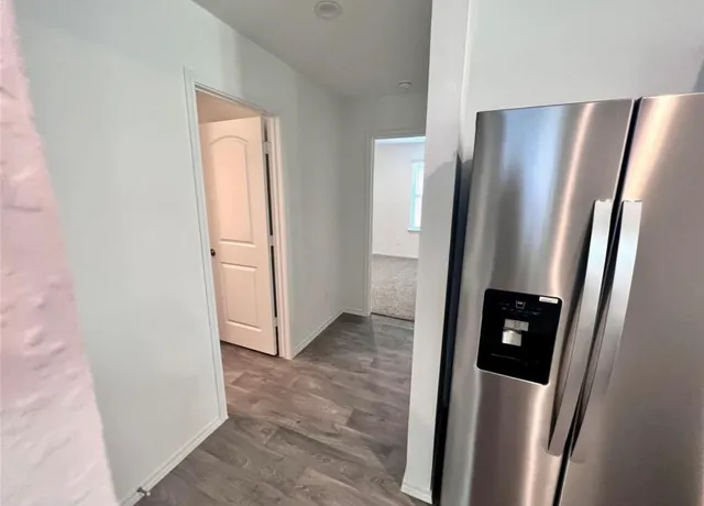 an empty room with wooden floor and a large window
