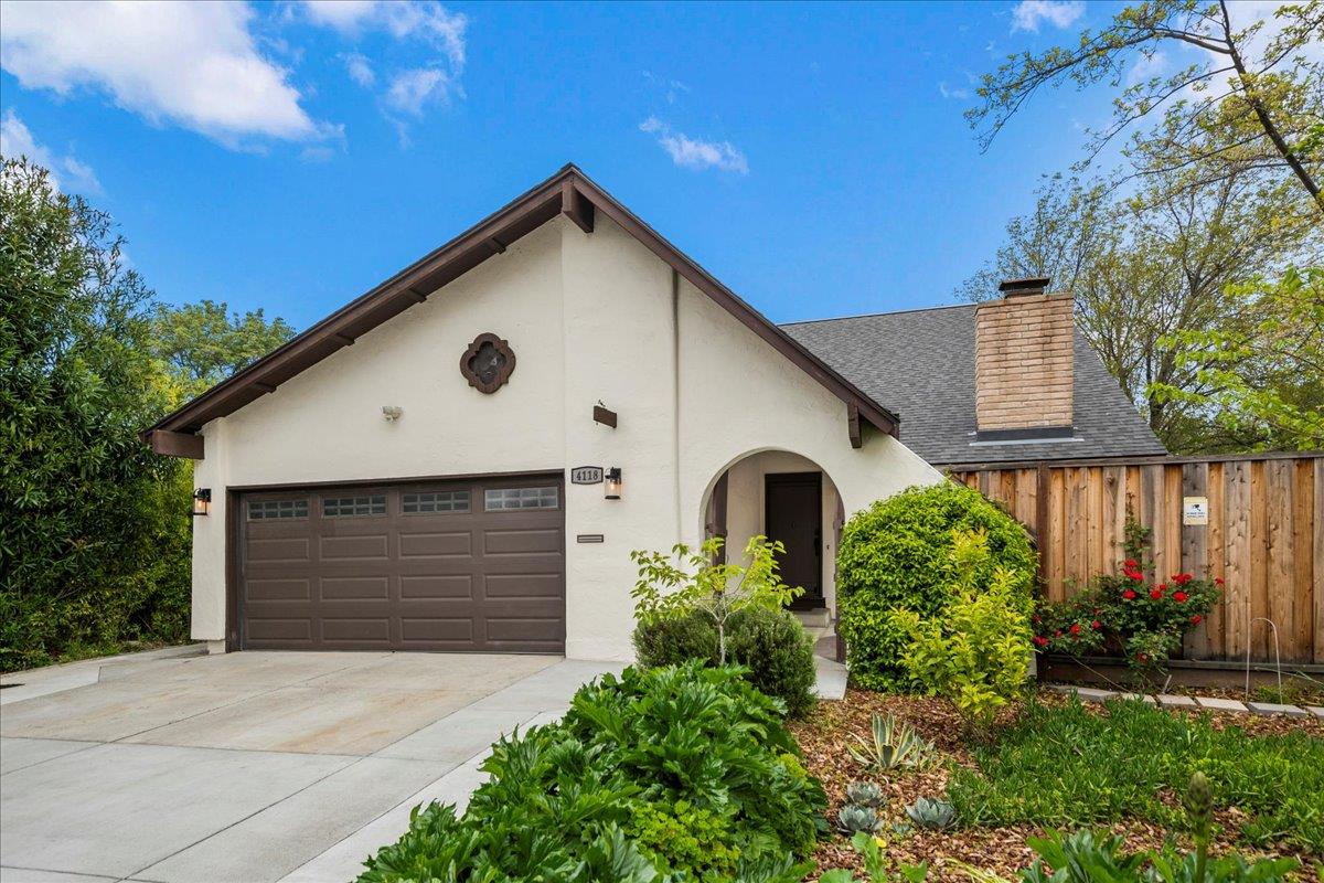 a front view of house with yard and trees in the background