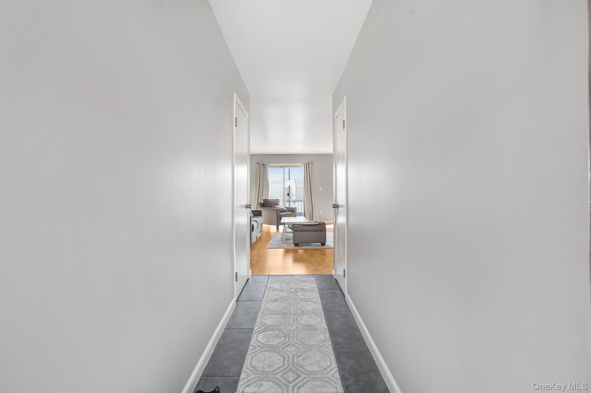 26 Cooper Road, Unit 411 Poughkeepsie, NY 12603 - Photo 6 of 17 Hallway with baseboards and dark tile patterned flooring
