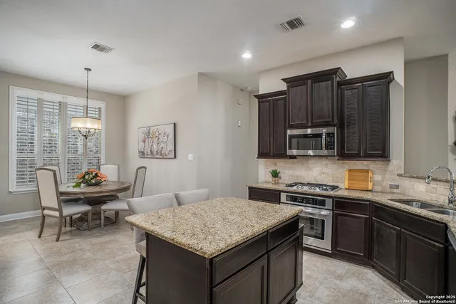 a kitchen with stainless steel appliances granite countertop a sink stove and microwave