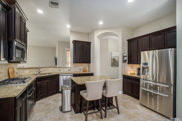 a kitchen with granite countertop a sink and stainless steel appliances