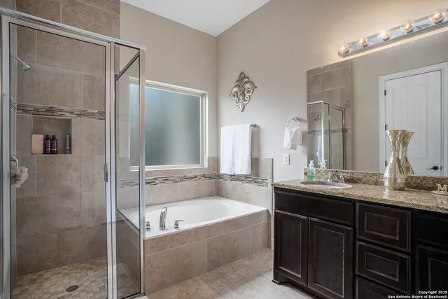 a bathroom with a tub sink shower and mirror