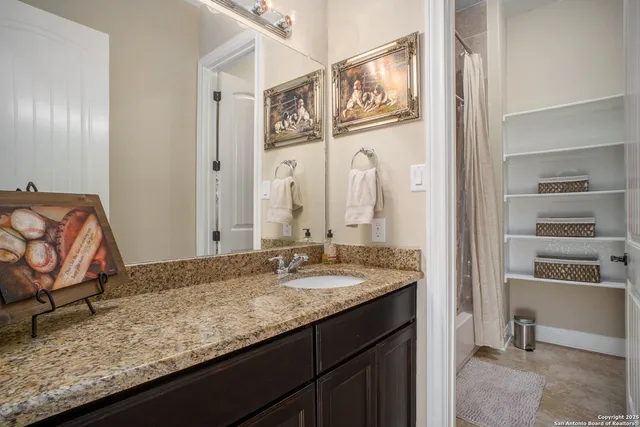 a bathroom with a granite countertop sink and a mirror