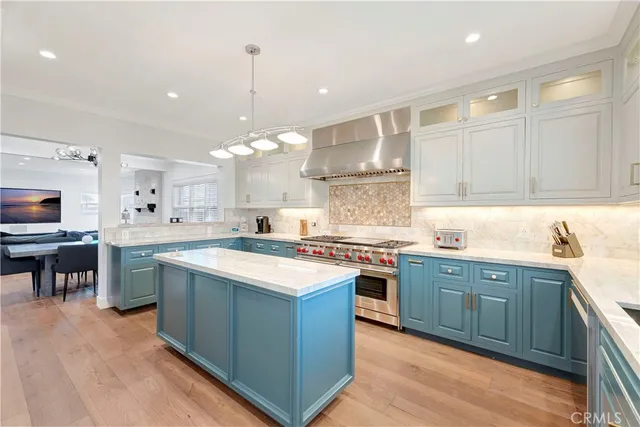 a large kitchen with stainless steel appliances granite countertop a lot of counter space and wooden floor