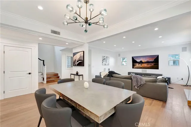 a living room with furniture kitchen view and a wooden floor