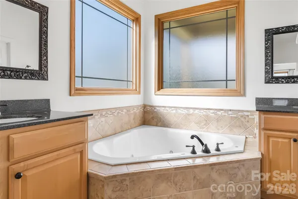 a bathroom with mirror sink and bathtub