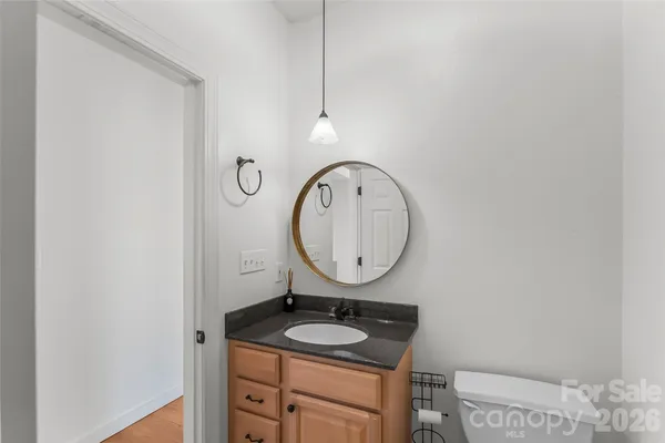 a bathroom with a granite countertop sink a mirror and a toilet
