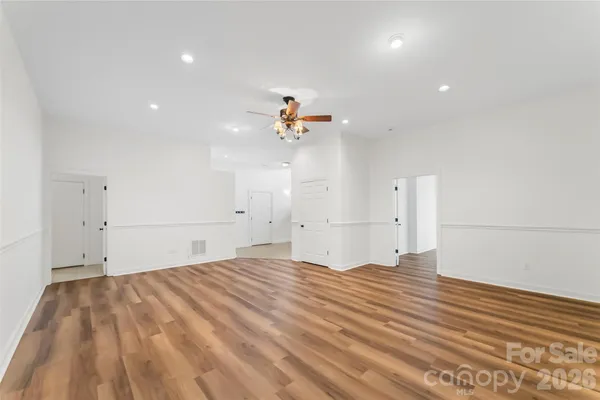 a view of a big room with wooden floor and a ceiling fan