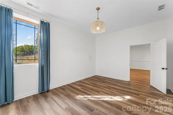 a view of a room with wooden floor and window