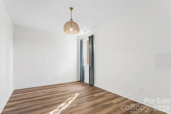 a view of a room with wooden floor and chandelier