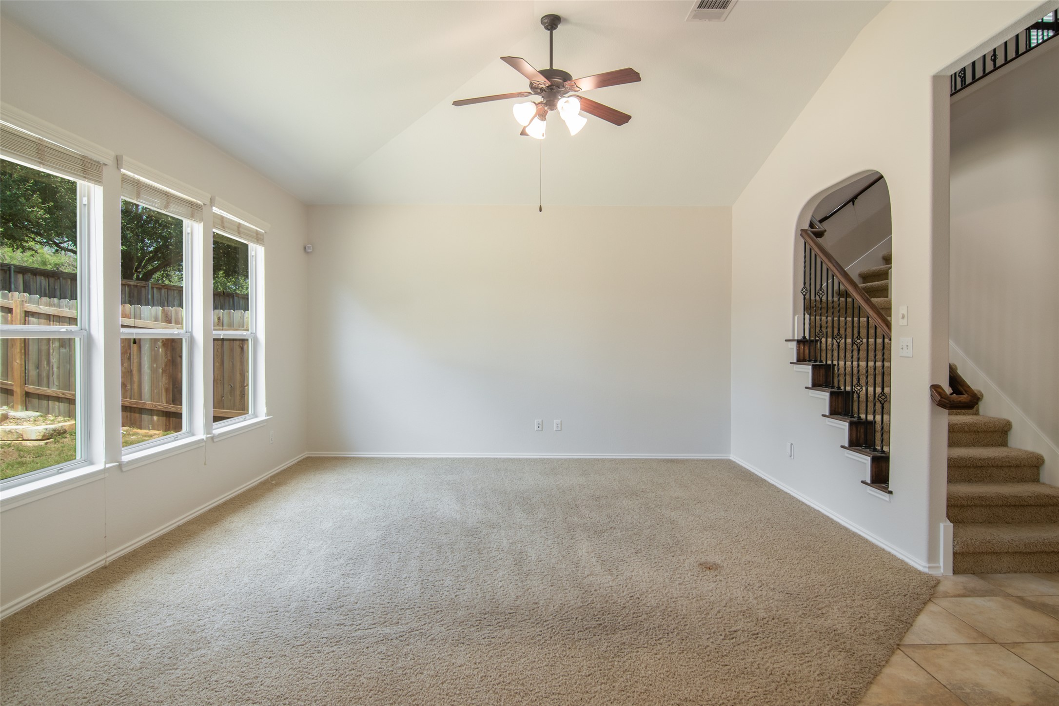 12104 Broten Street Austin, TX 78748 - Photo 5 of 32 A well-lit living area features tall windows and a practical staircase leading to upper levels.