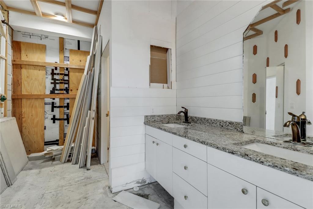 481 Raven Way Naples, FL 34110 - Photo 15 of 30 a bathroom with a granite countertop sink and a mirror