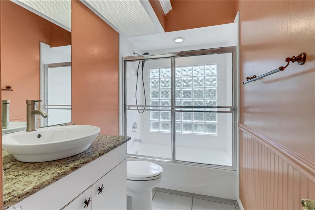 481 Raven Way Naples, FL 34110 - Photo 21 of 30 a bathroom with a granite countertop sink toilet and shower