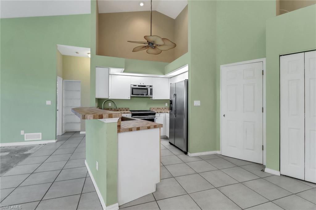 481 Raven Way Naples, FL 34110 - Photo 9 of 30 a kitchen with a refrigerator a sink dishwasher a refrigerator and a stove top oven
