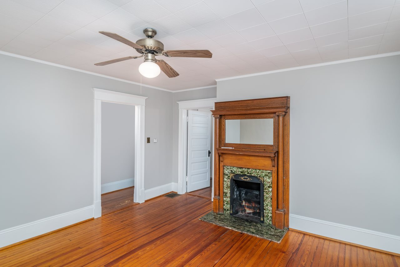 109 North Bloodworth Street Raleigh, NC 27601 - Photo 13 of 30 a view of an empty room with wooden floor a fireplace and a window