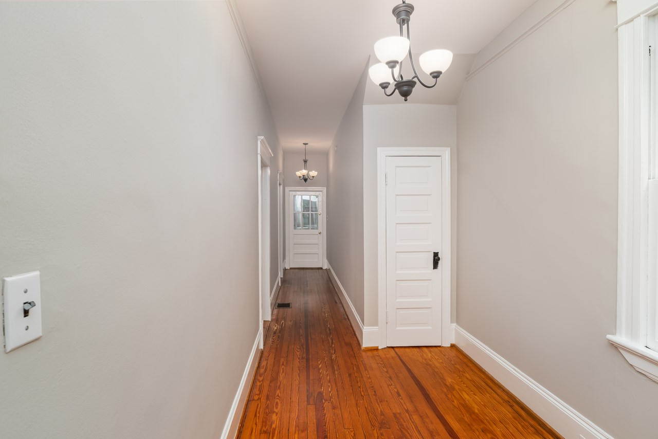 109 North Bloodworth Street Raleigh, NC 27601 - Photo 18 of 30 a view of a hallway with wooden floor and a chandelier