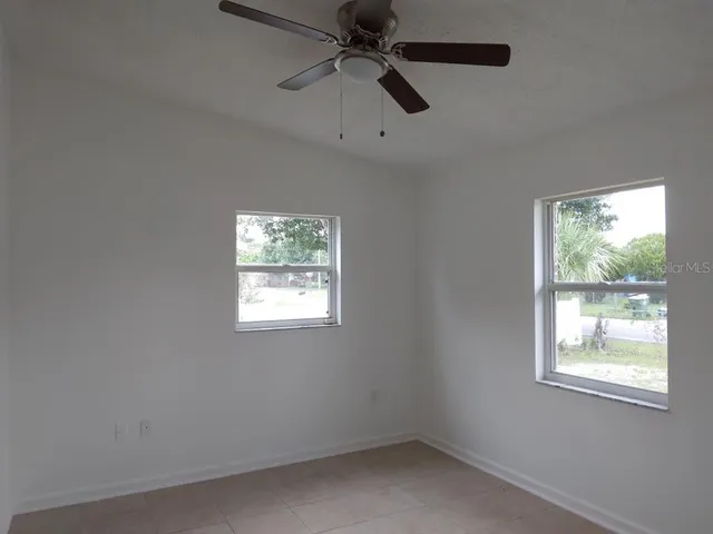 an empty room with a window and a fan