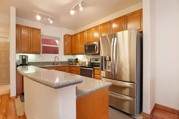 a kitchen with granite countertop stainless steel appliances and wooden cabinets