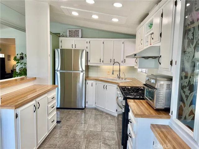 a kitchen with stainless steel appliances granite countertop a refrigerator and a stove top oven