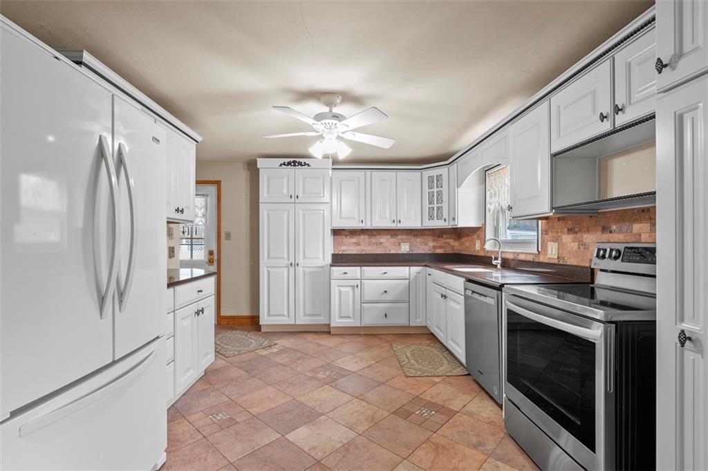 391 Golden Grove Road Baden, PA 15005 - Photo 16 of 34 a kitchen with granite countertop a refrigerator stove and sink