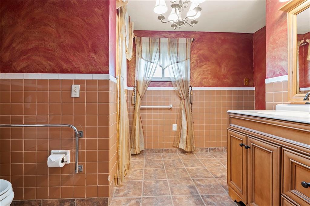 391 Golden Grove Road Baden, PA 15005 - Photo 19 of 34 a bathroom with a granite countertop sink a toilet and a mirror
