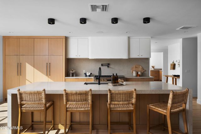 a kitchen with a dining table chairs and white cabinets