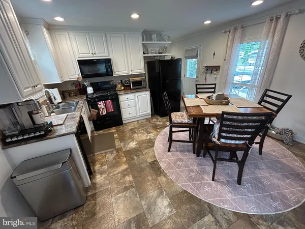 a living room with furniture a flat screen tv and a refrigerator
