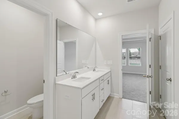a bathroom with a double vanity sink toilet and shower