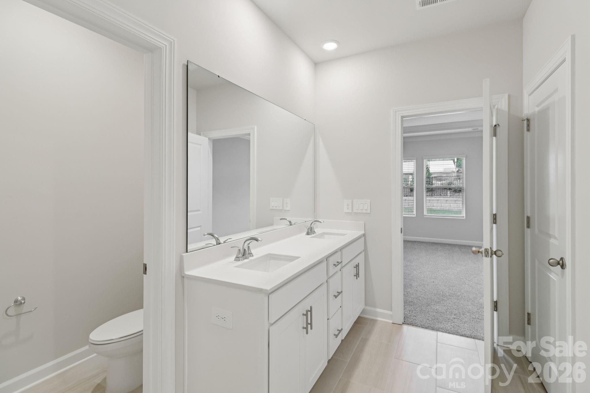 2449 Chartwell Street Stanley, NC 28164 - Photo 14 of 23 a bathroom with a double vanity sink toilet and shower