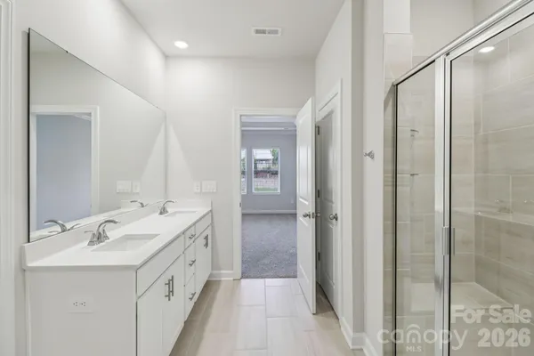 a bathroom with a double vanity sink mirror and shower