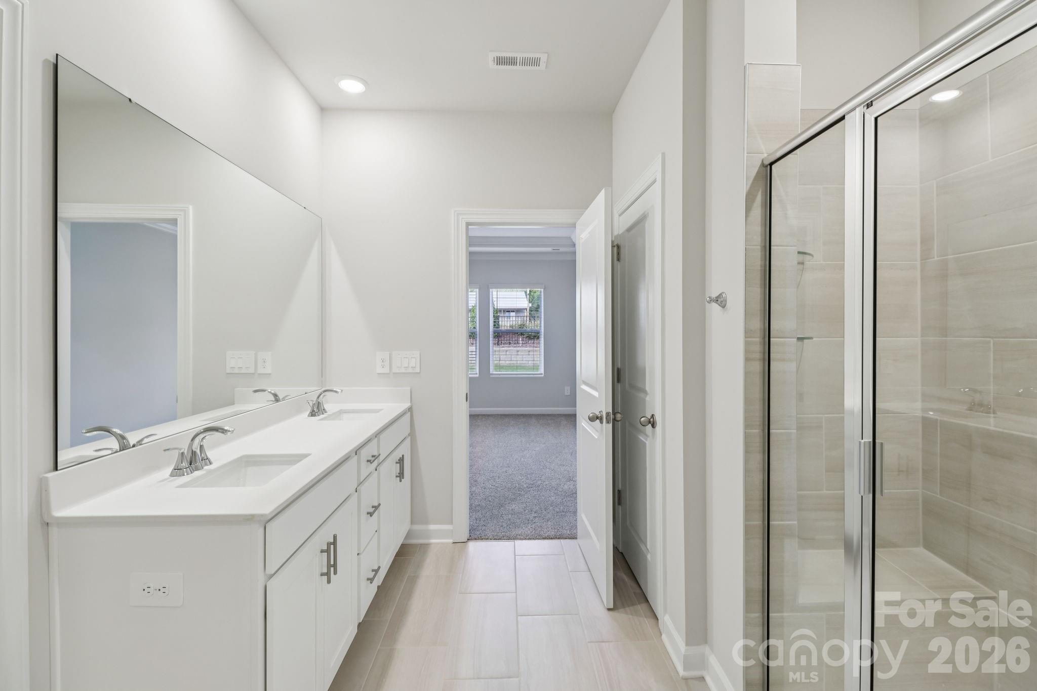 2449 Chartwell Street Stanley, NC 28164 - Photo 15 of 23 a bathroom with a double vanity sink mirror and shower