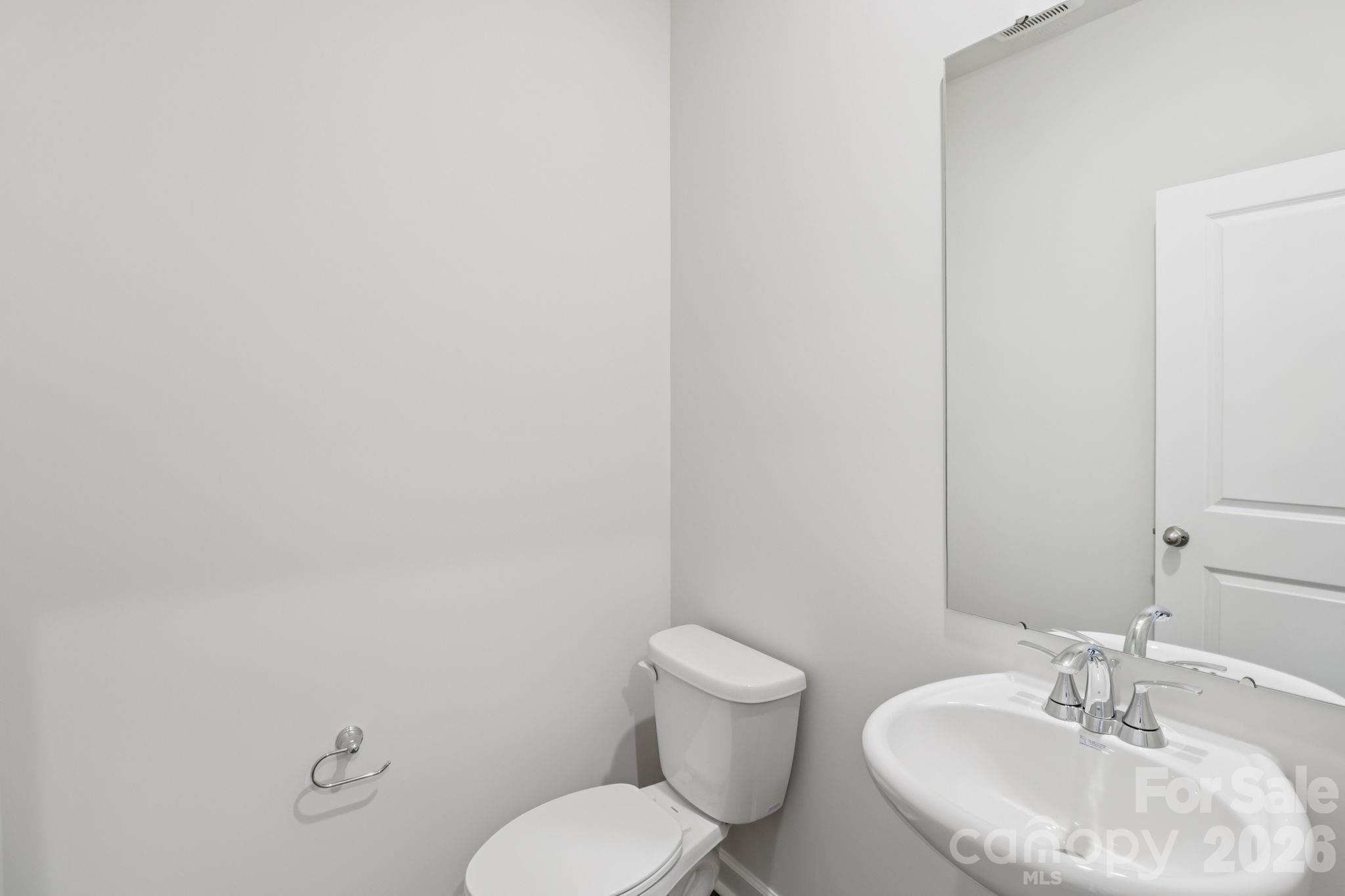 2449 Chartwell Street Stanley, NC 28164 - Photo 18 of 23 a bathroom with a toilet a sink and mirror