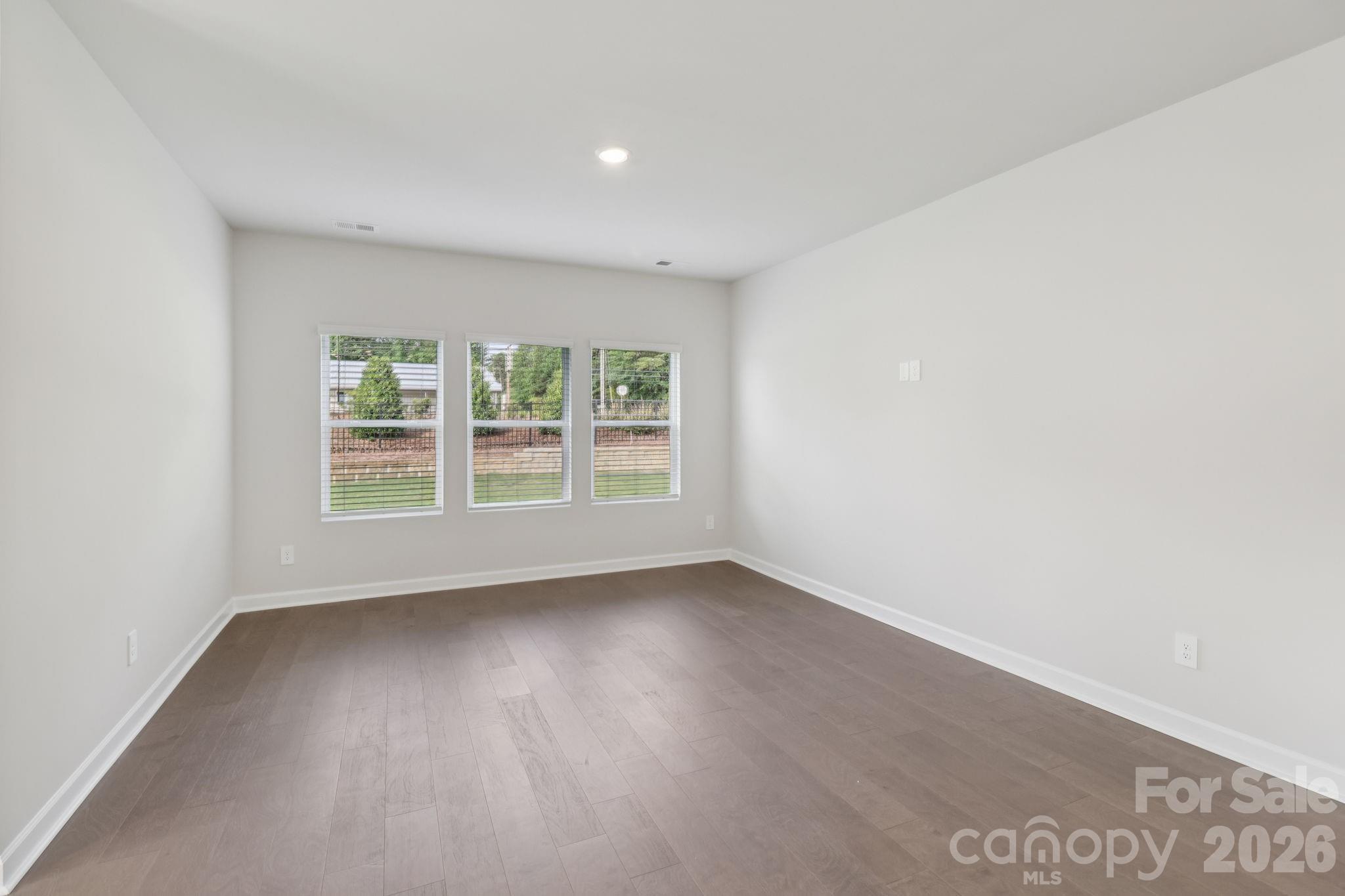2449 Chartwell Street Stanley, NC 28164 - Photo 3 of 23 an empty room with wooden floor and windows