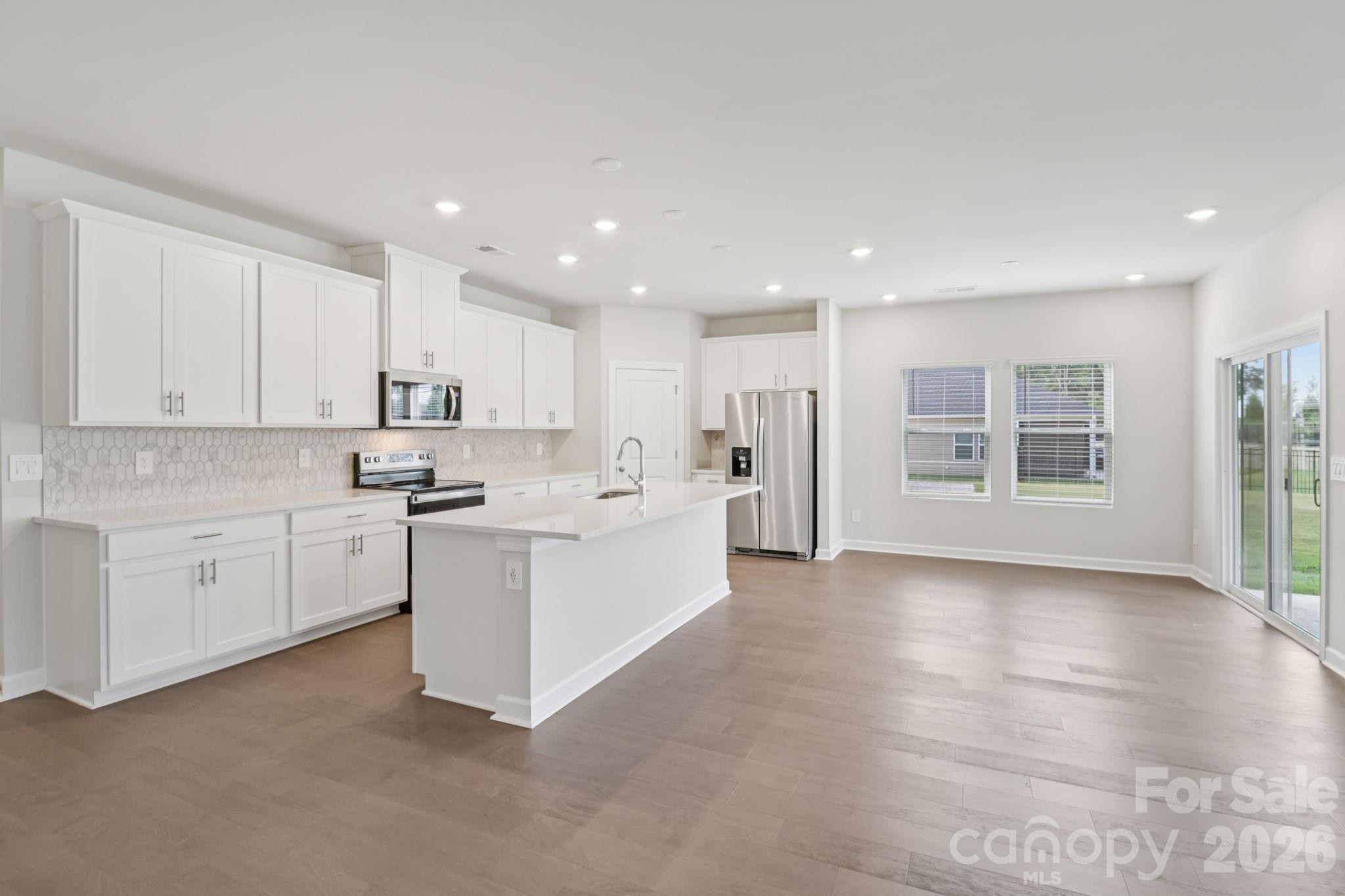 2449 Chartwell Street Stanley, NC 28164 - Photo 6 of 23 a kitchen with white cabinets and white appliances