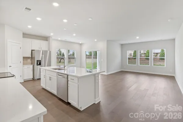 a large kitchen with stainless steel appliances granite countertop a large counter top a stove and a refrigerator
