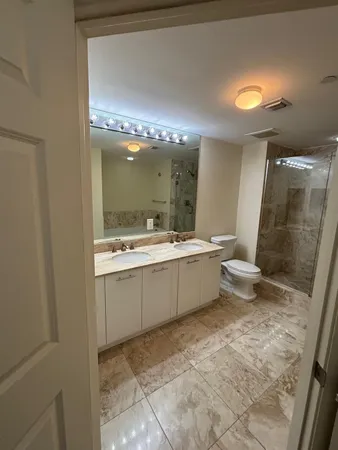a bathroom with a sink mirror vanity and toilet
