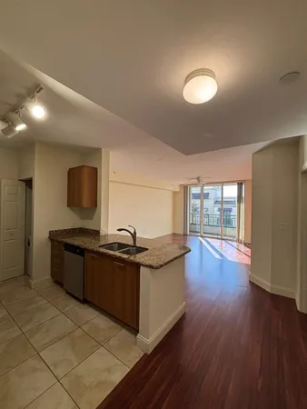 a kitchen with stainless steel appliances granite countertop a stove and a wooden floors