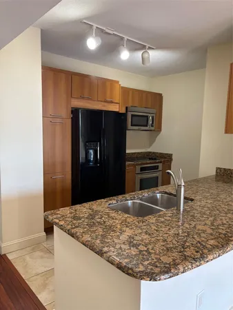 a kitchen with kitchen island a counter top and a sink