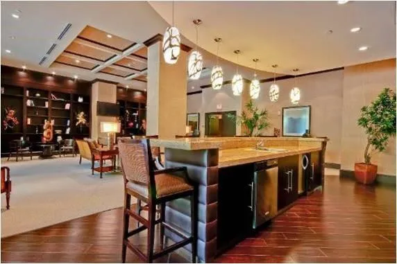 a kitchen with stainless steel appliances granite countertop a table and chairs a wooden floor