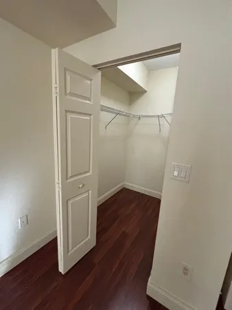 an empty room with wooden floor and closet