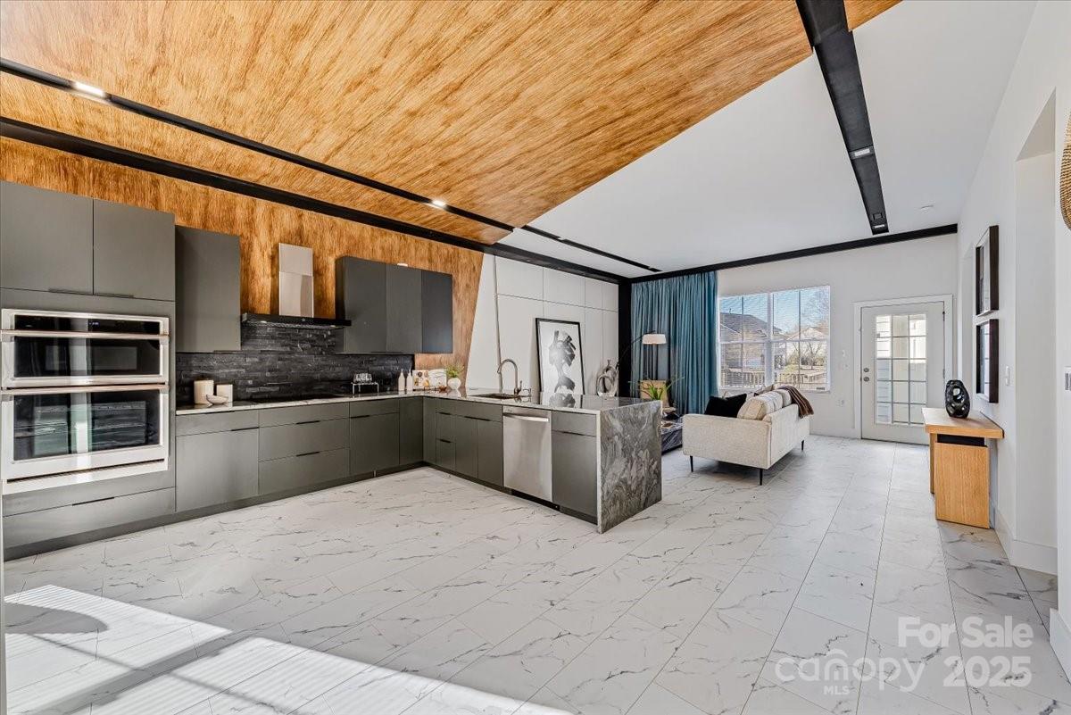 6517 Old Magnolia Lane Mint Hill, NC 28227 - Photo 7 of 46 a large white open kitchen with stainless steel appliances kitchen island granite countertop a refrigerator stove oven a sink with island and couches