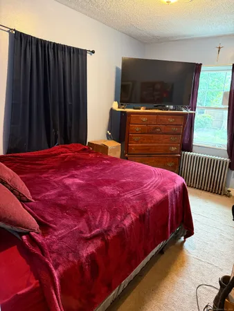 a bed sitting in a bedroom next to a window