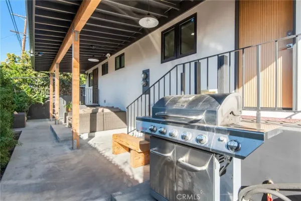 a living room with stainless steel appliances a table and a flat screen tv