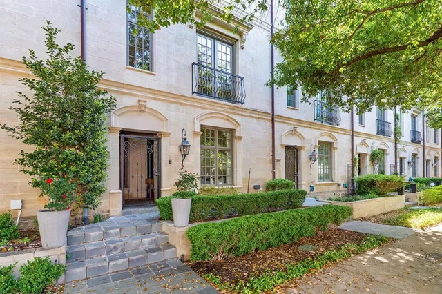 a front view of a house with garden and trees